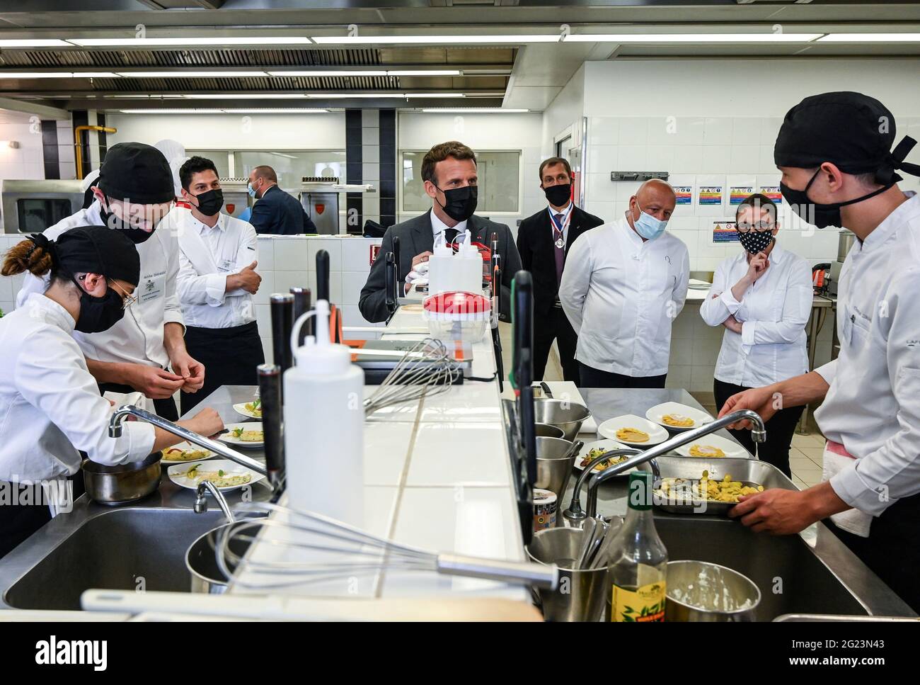 Der französische Präsident Emmanuel Macron und die Köche Thierry Marx und  Anne-Sophie Pic beobachten, wie Schüler in der Küche der Hospitality School  in Tain l'Hermitage, Departement Drome, Frankreich, Essen zubereiten, 8.  Juni