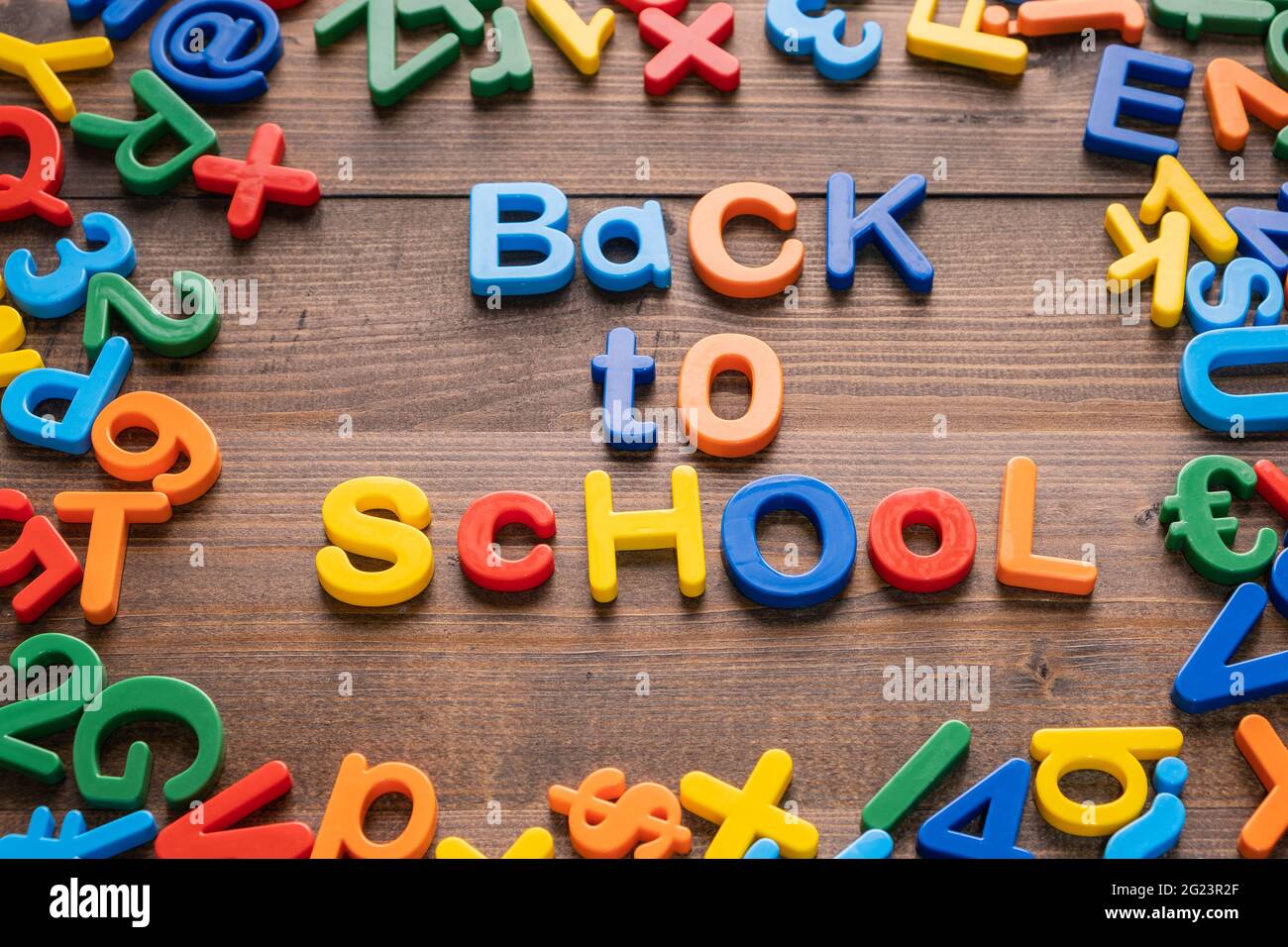 Buntes Plastikwort 'Back to School' auf Holzhintergrund Stockfoto
