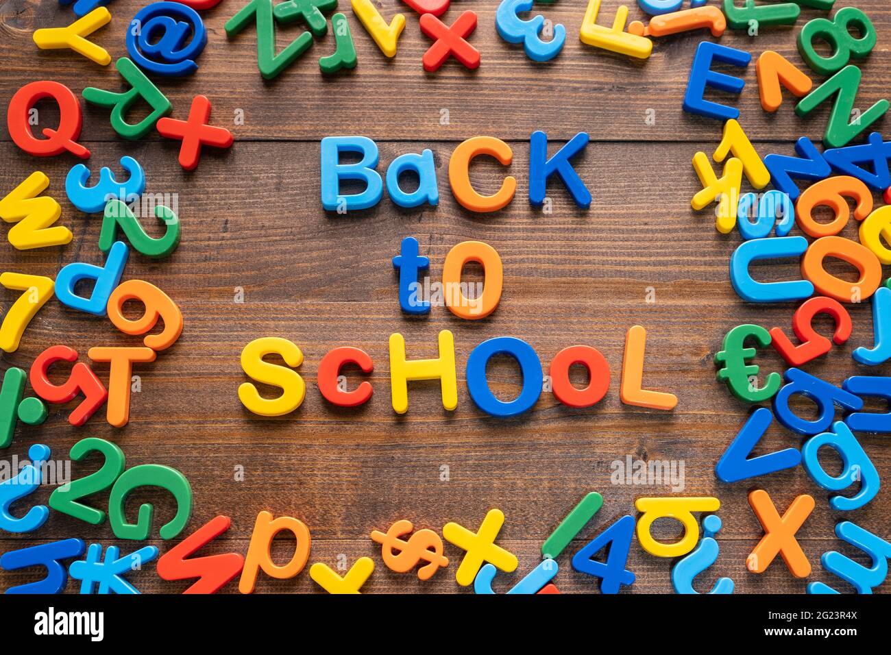 Buntes Plastikwort 'Back to School' auf Holzhintergrund Stockfoto