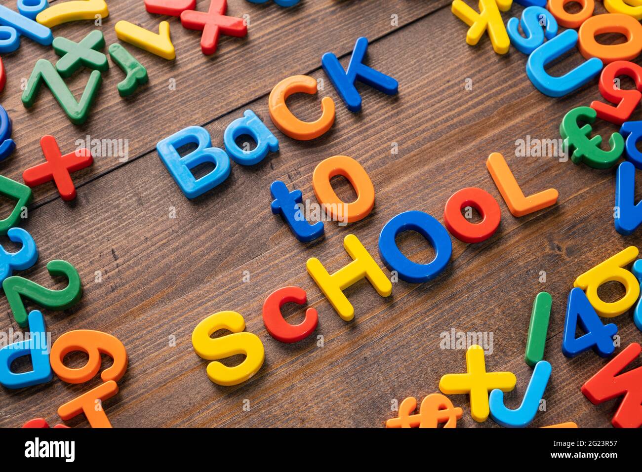 Buntes Plastikwort 'Back to School' auf Holzhintergrund Stockfoto