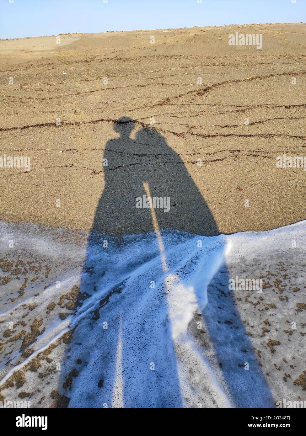 Zwei lange Schatten eines liebevollen Paares am schönen einsamen Strand in frankreich Stockfoto