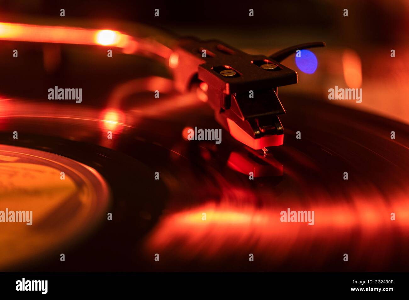 Nahaufnahme einer Nadel eines Plattenspielers auf der Schallplatte in rotem Licht Stockfoto