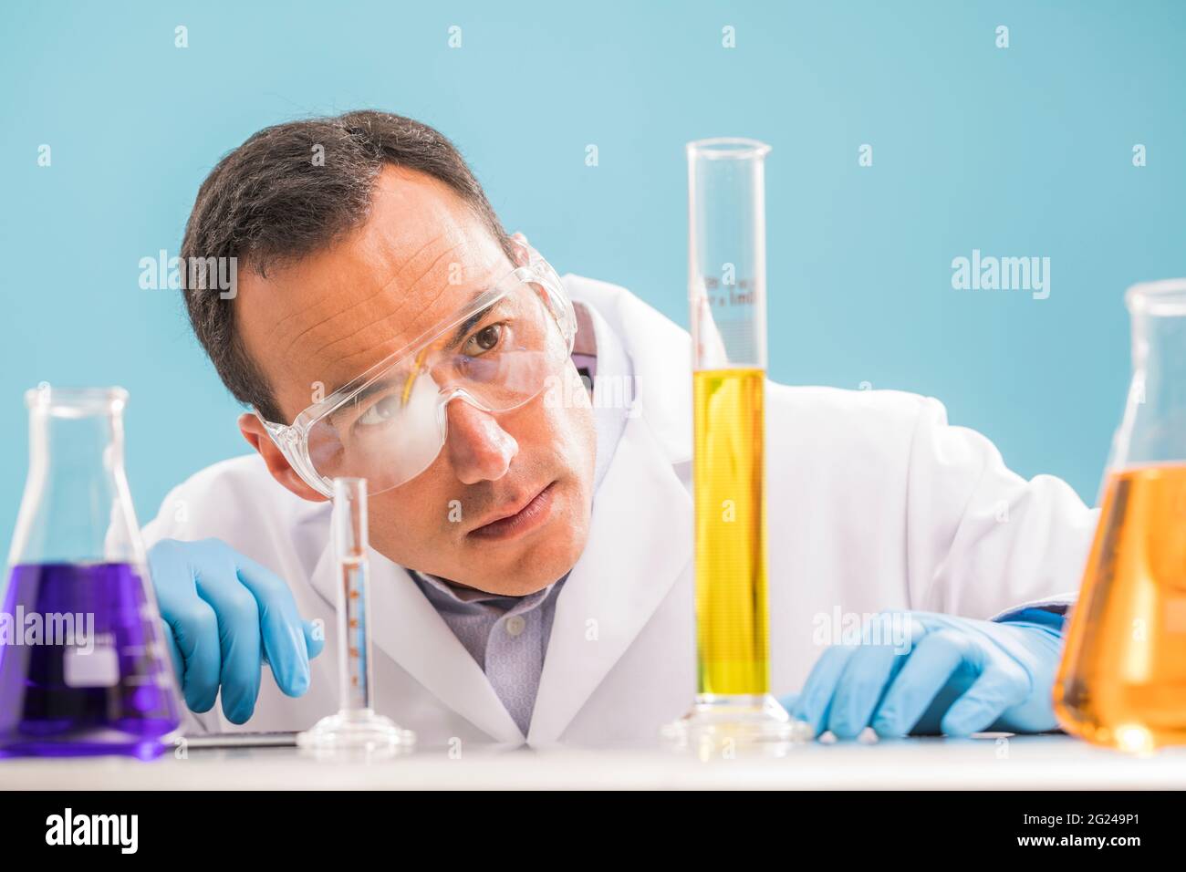 Wissenschaftler, die gelbe Flüssigkeit im Messbecher betrachten Stockfoto