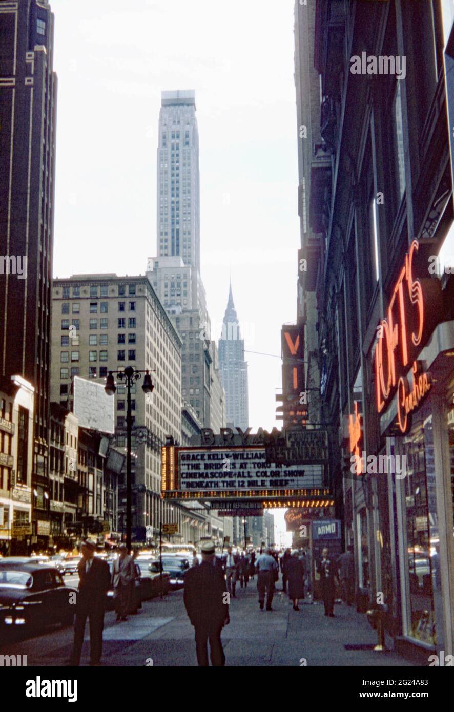 Blick Richtung Westen 42nd Street, New York City, USA im Jahr 1955. Das Bryant Theatre zeigt ‘The Bridges of Toko-Ri’, einen koreanischen Kriegsfilm mit Grace Kelly und William Holden. In der Ferne befindet sich der berühmte Art déco-Wolkenkratzer des Chrysler Building. Hell erleuchtet von Neon, ist es der Mittelpunkt des Broadway Theatre District. Dieses Bild stammt aus einer alten Kodak Farbtransparenz, die von einem Amateurfotografen aufgenommen wurde – einem Vintage-Foto aus den 1950er Jahren. Stockfoto