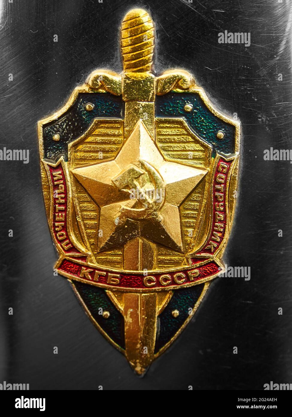 Bildliches, repräsentatives Bild des Abzeichen / Insignien der KGB-Sicherheitsbehörde, angebracht an einer Metallflasche (vom Fotografen selbst) - Metallhintergrund. Stockfoto