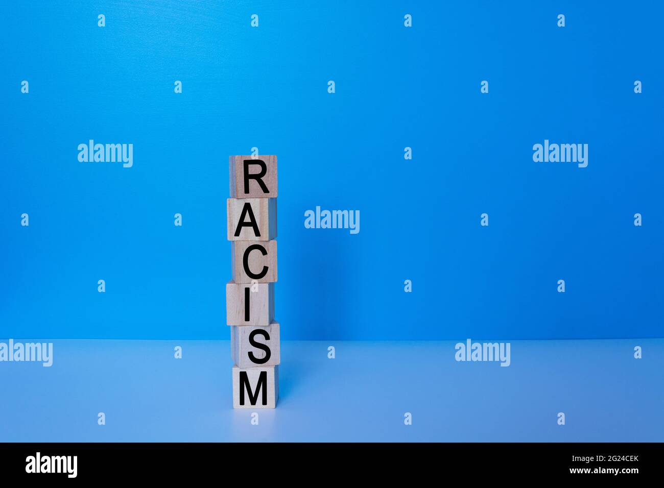 Rassismus Text auf Holzblock oder Würfel mit blauem Hintergrund Stockfoto