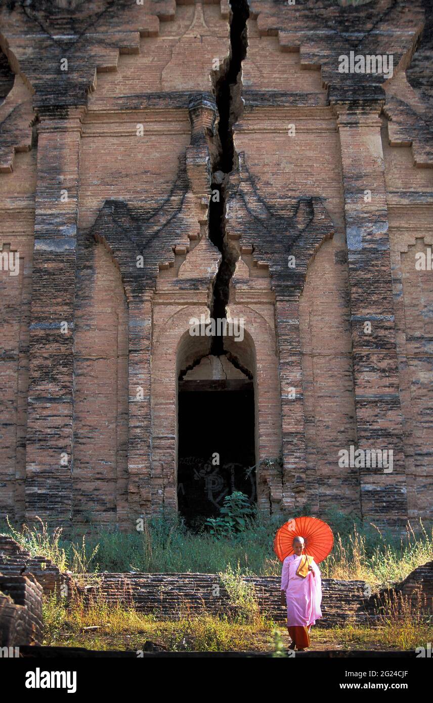 Myanmar, Mingun, Mandalay Division, buddhistische Nonne vor einem alten buddhistischen Tempel, der durch Erdbeben ruiniert wurde Stockfoto