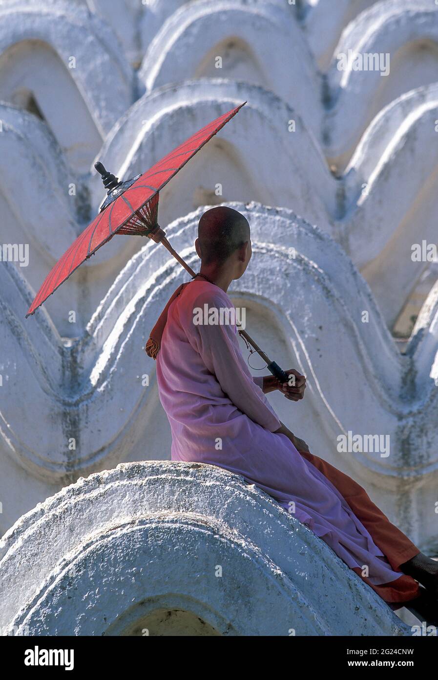 Myanmar, Mingun, Mandalay Division, buddhistische Nonne, die auf weißen Bögen der Hsinbyume-Pagode sitzt Stockfoto