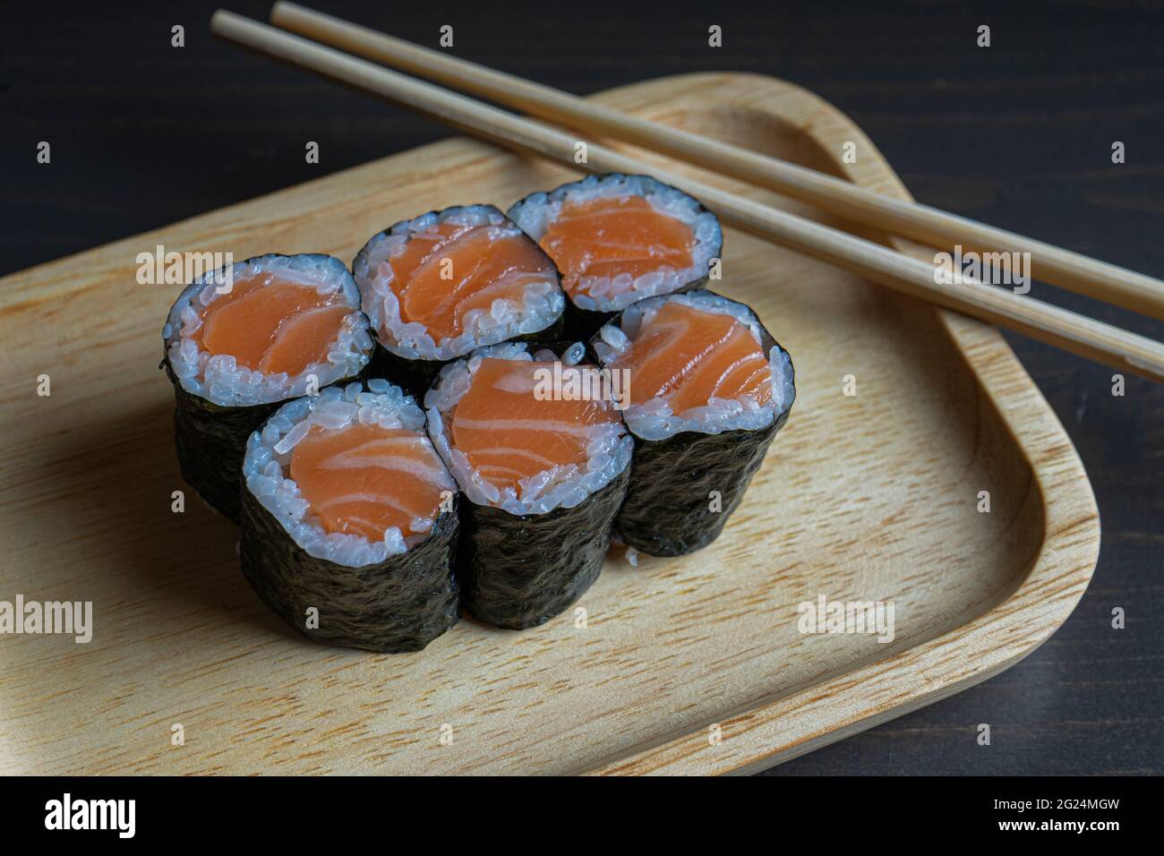 Maki rollt mit geräuchertem Lachs auf einem Holzteller Stockfoto