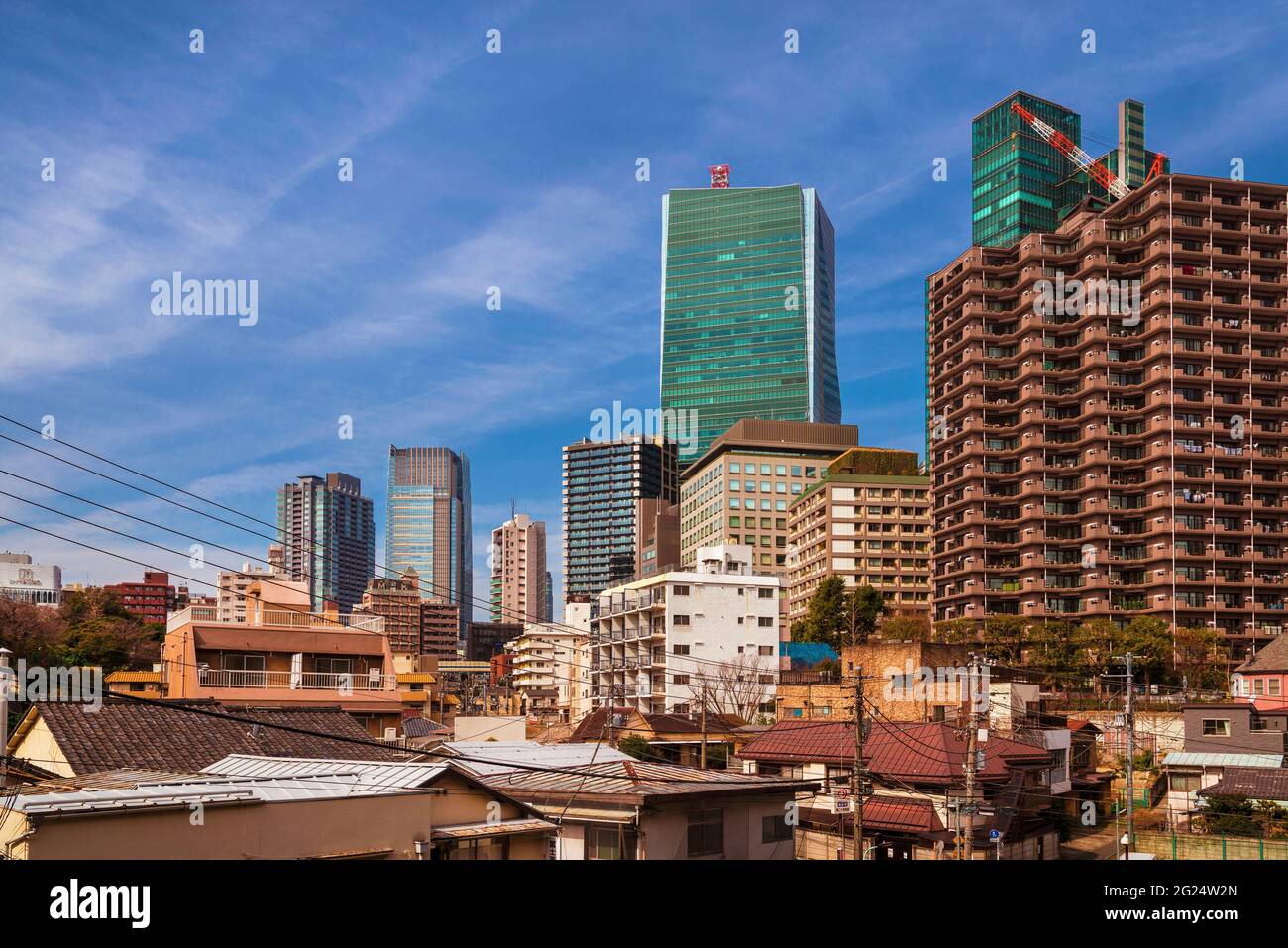 Kontrast in Tokio. Moderne Wolkenkratzer und altmodische Gebäude nebeneinander im Viertel Roppongi Stockfoto