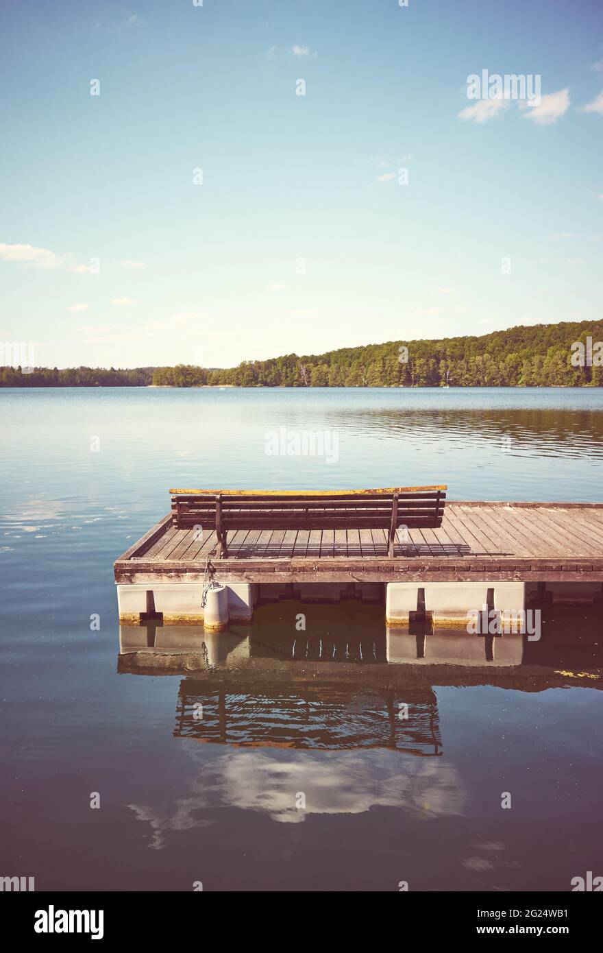 Bank auf einem hölzernen schwimmenden Pier, Farbtonung angewendet, Lipie-See in Dlugie Village, Polen. Stockfoto