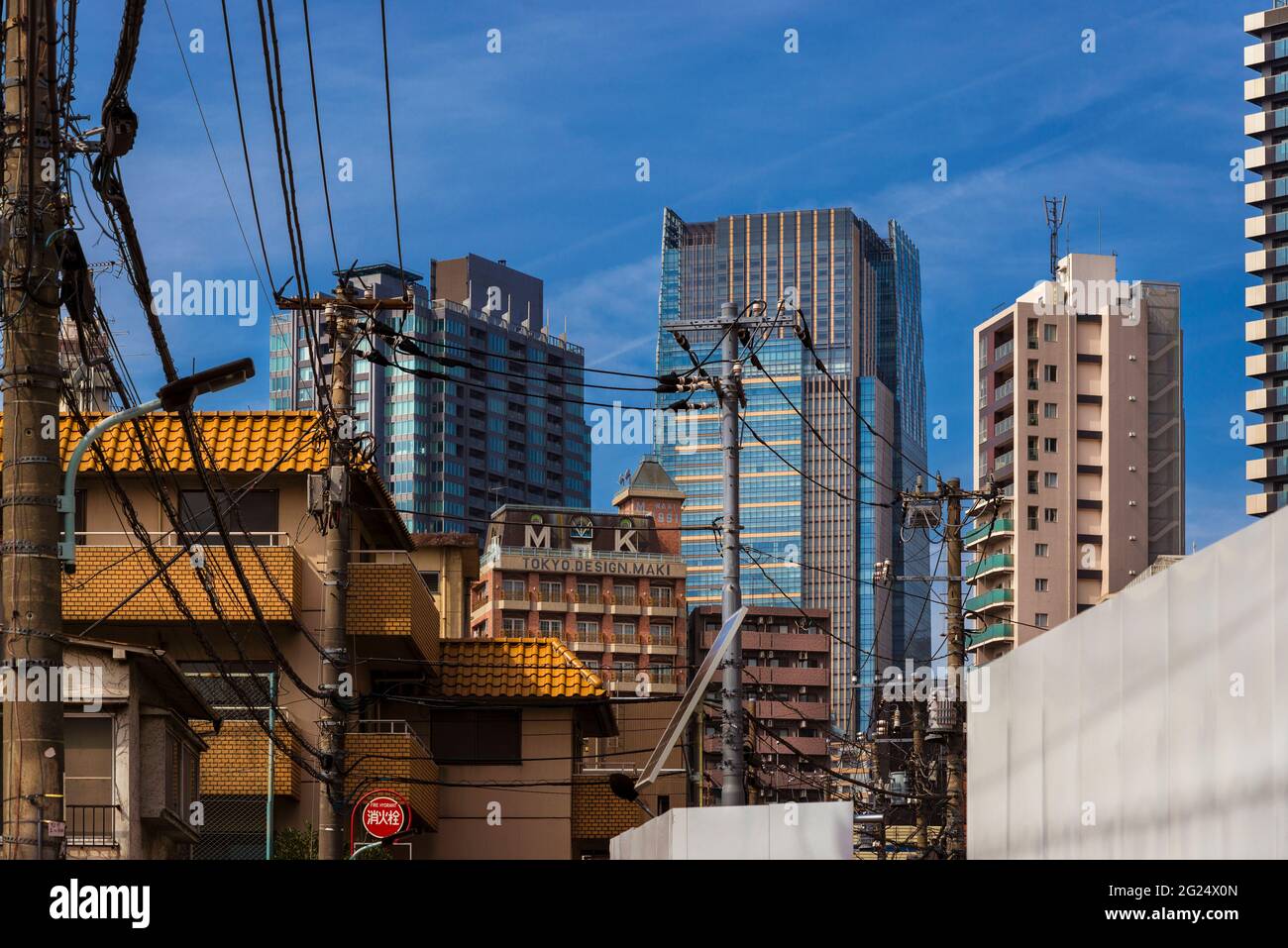 Kontrast in Tokio. Gewöhnliche Gebäude unter modernen Wolkenkratzern im Viertel Roppongi Stockfoto