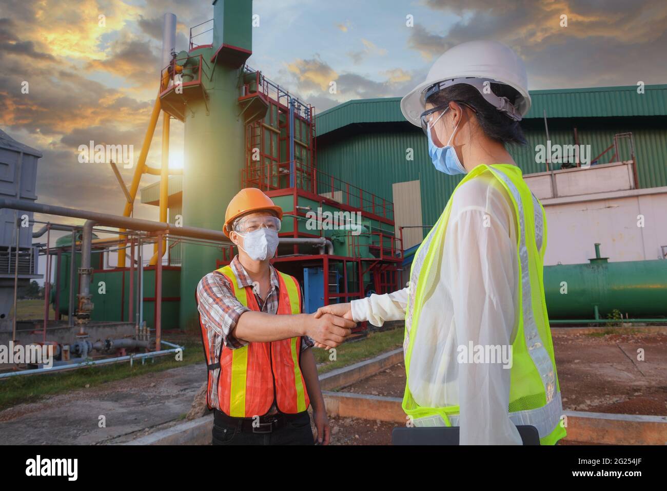 Zwei Ingenieure schüttelten sich die Hände vor einer Fabrik in Thailand Stockfoto