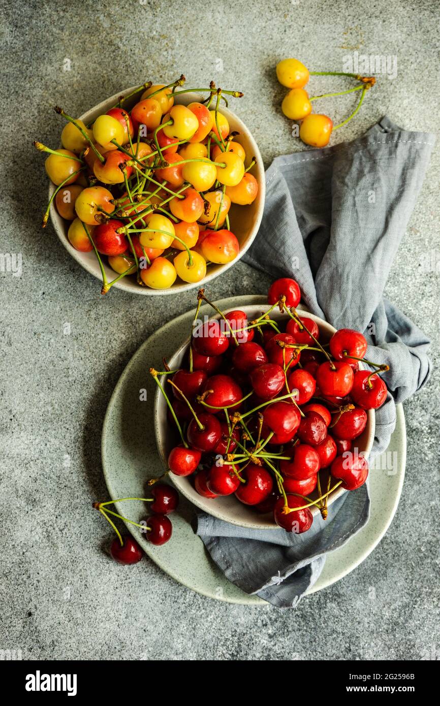 Blick von oben auf Schalen mit roten und gelben Kirschen Stockfoto