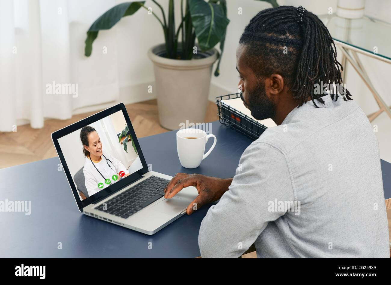 Videokonferenz mit einem Arzt. Afroamerikanischer Erwachsener während einer medizinischen Online-Konferenz mit seinem Hausarzt Stockfoto