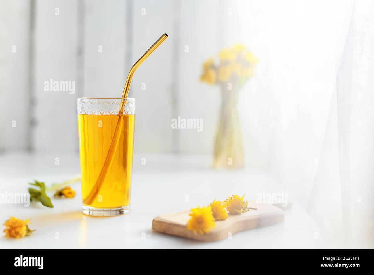 Dandelion Honigsaft in einem Glas mit einem Metallrohr und frischen Blumen. Mit Kopierraum. Stockfoto