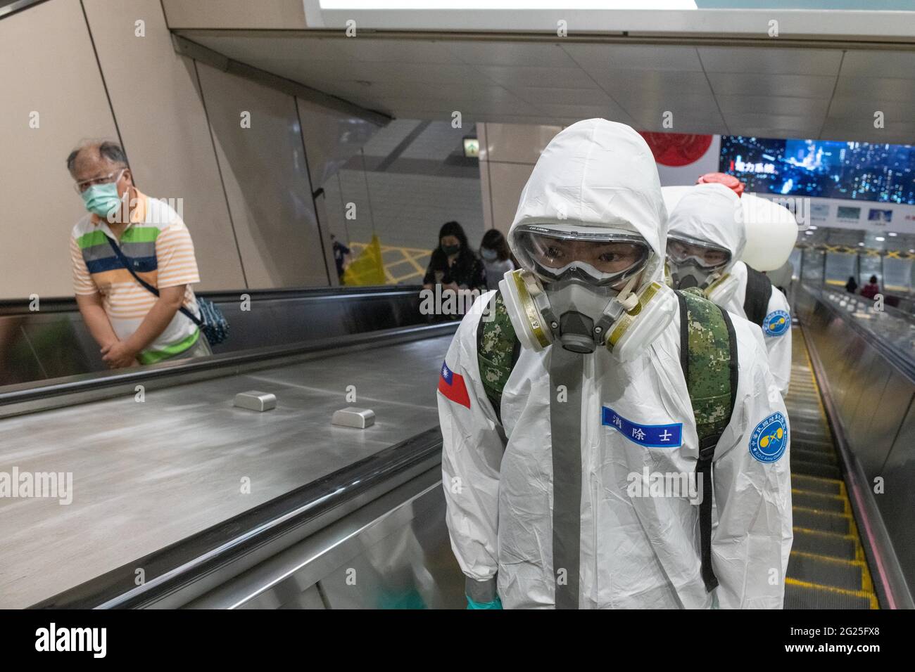 Taipeh, Taiwan. Juni 2021. Soldaten in einer MRT-Station bereiten sich darauf vor, in Taipei Desinfektionsmittel zu sprühen, während Taiwan seinen schlimmsten Ausbruch seit Beginn der Pandemie erlebt. Nach einem Anstieg lokaler Infektionen erhöhte Taiwans Alarm auf Level-3, schloss Schulen, Freizeiteinrichtungen und verhängt die Mitnahme von Restaurants. In allen öffentlichen Bereichen werden Gesichtsmasken getragen. Quelle: Brennan O'Connor/ZUMA Wire/Alamy Live News Stockfoto