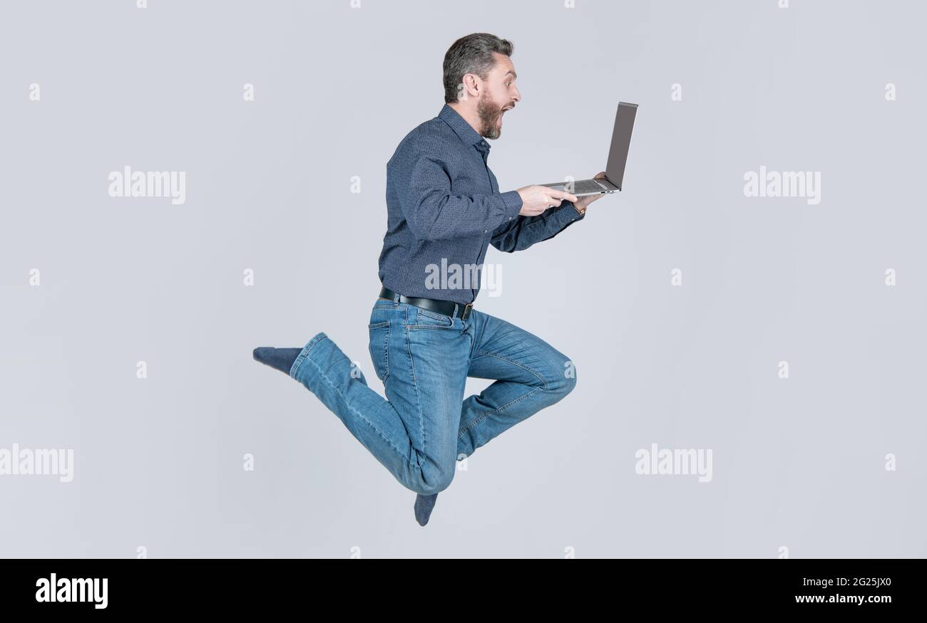 Überrascht energisch springenden Mann läuft online auf Laptop arbeiten beeilen Sie sich zum Einkaufen, Geschäft Stockfoto