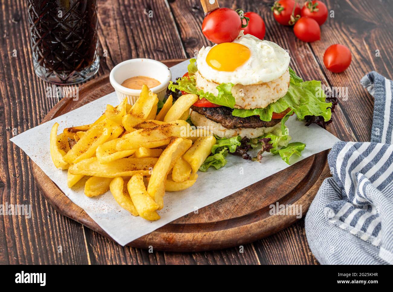 Koreanischer Burger mit Ei, Reis und frittierten Pommes auf Holzgrund Stockfoto