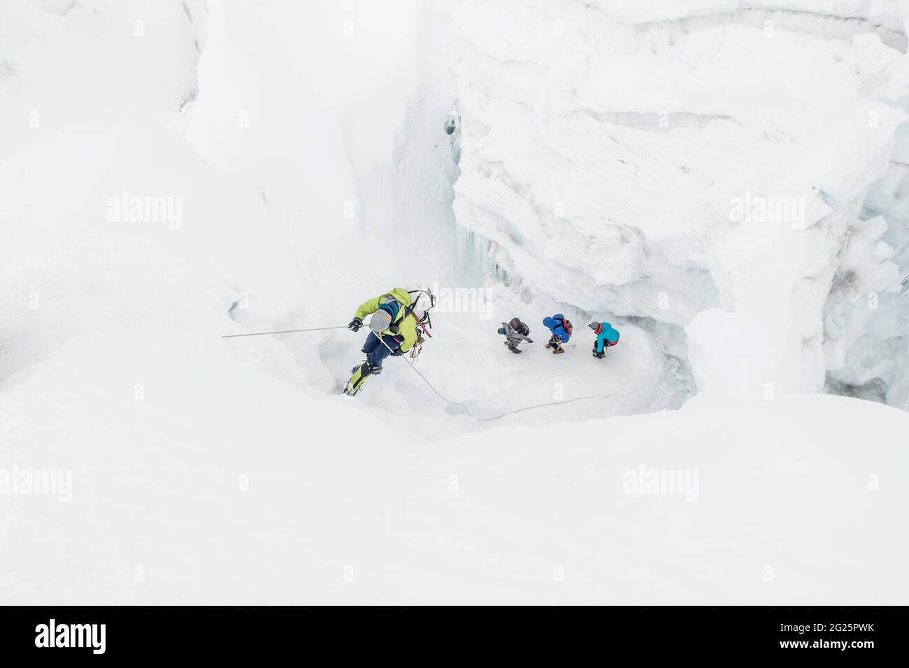 Kletterer auf dem Abseilen, während das Team durch den Eisfall navigiert Stockfoto