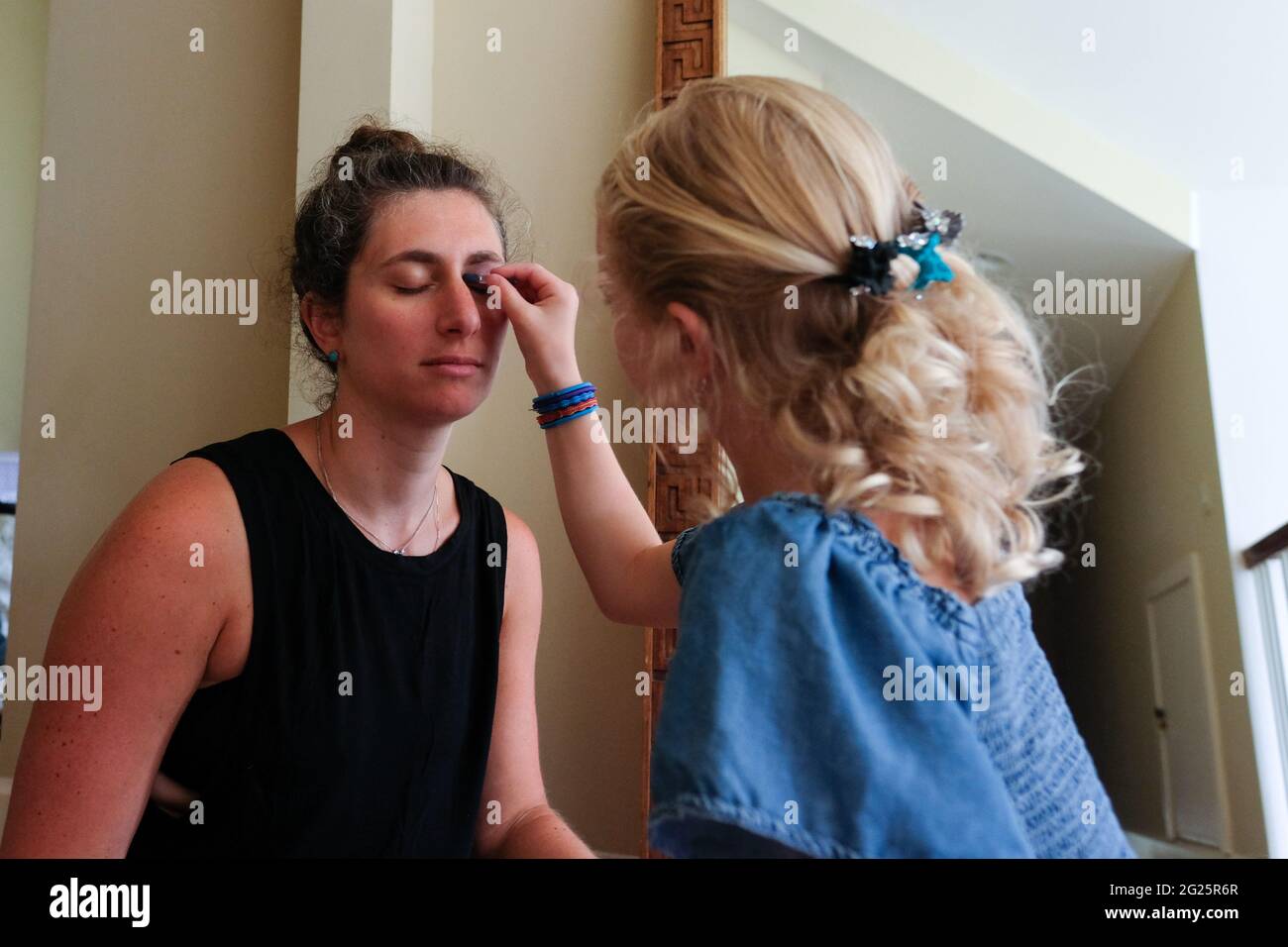 Kleine Mädchen setzen Make-up Mama Stockfoto