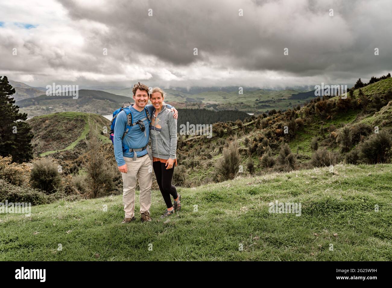 Aktives Paar mittleren Alters in Neuseeland, das mit Bergen im Hintergrund steht Stockfoto