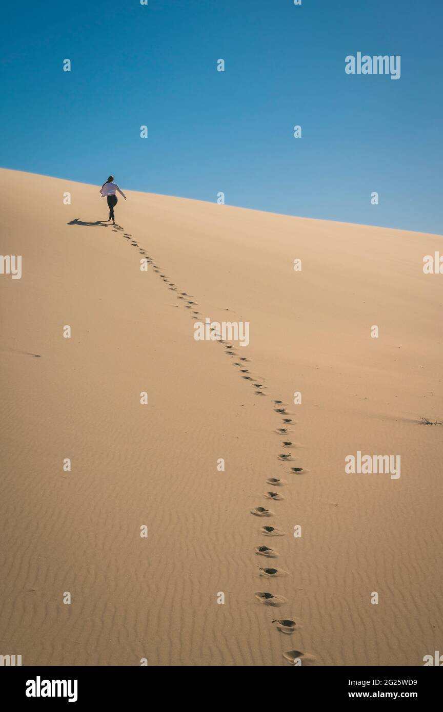 Weibliche Wanderung auf EINER Sanddüne in Oregon Stockfoto