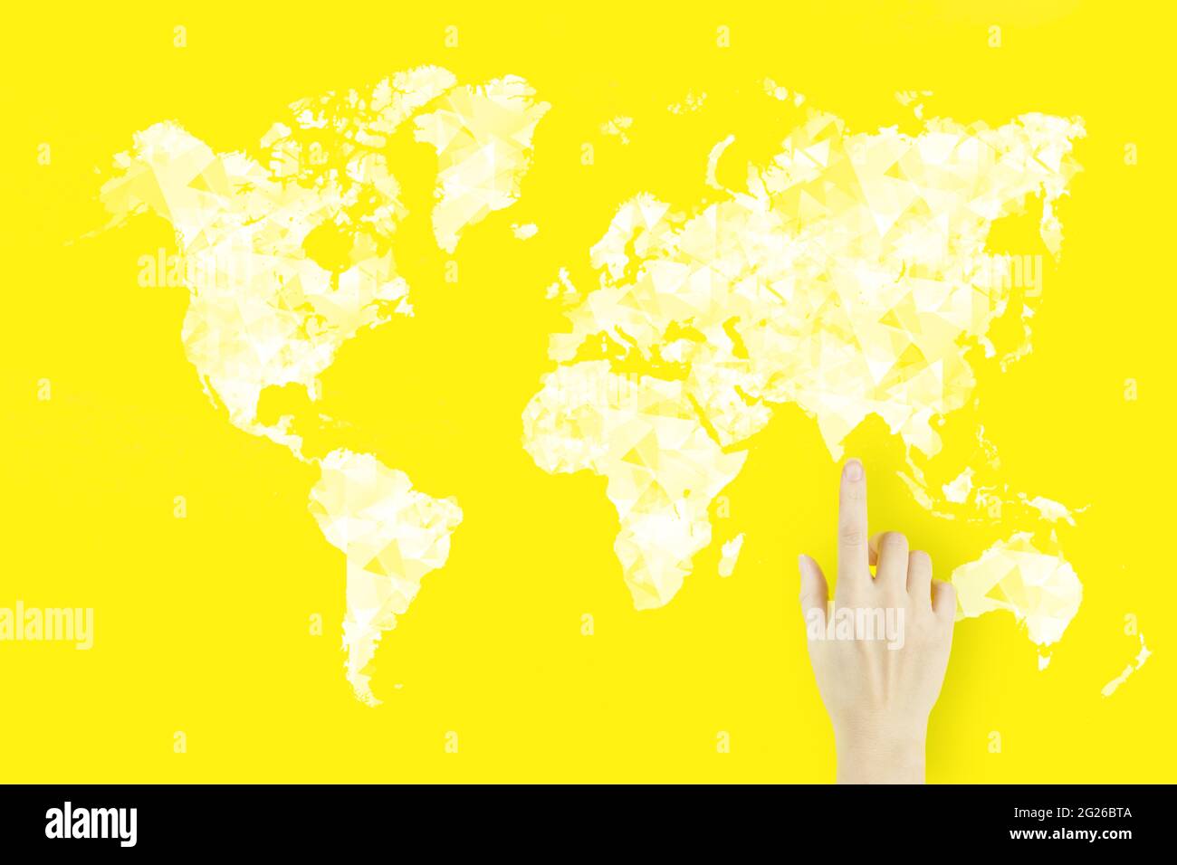 Verbindung zur Weltkarte in der Hand. Globales Verbindungskonzept. Der Handfinger der jungen Frau zeigt mit einem Hologramm auf gelbem Hintergrund Stockfoto