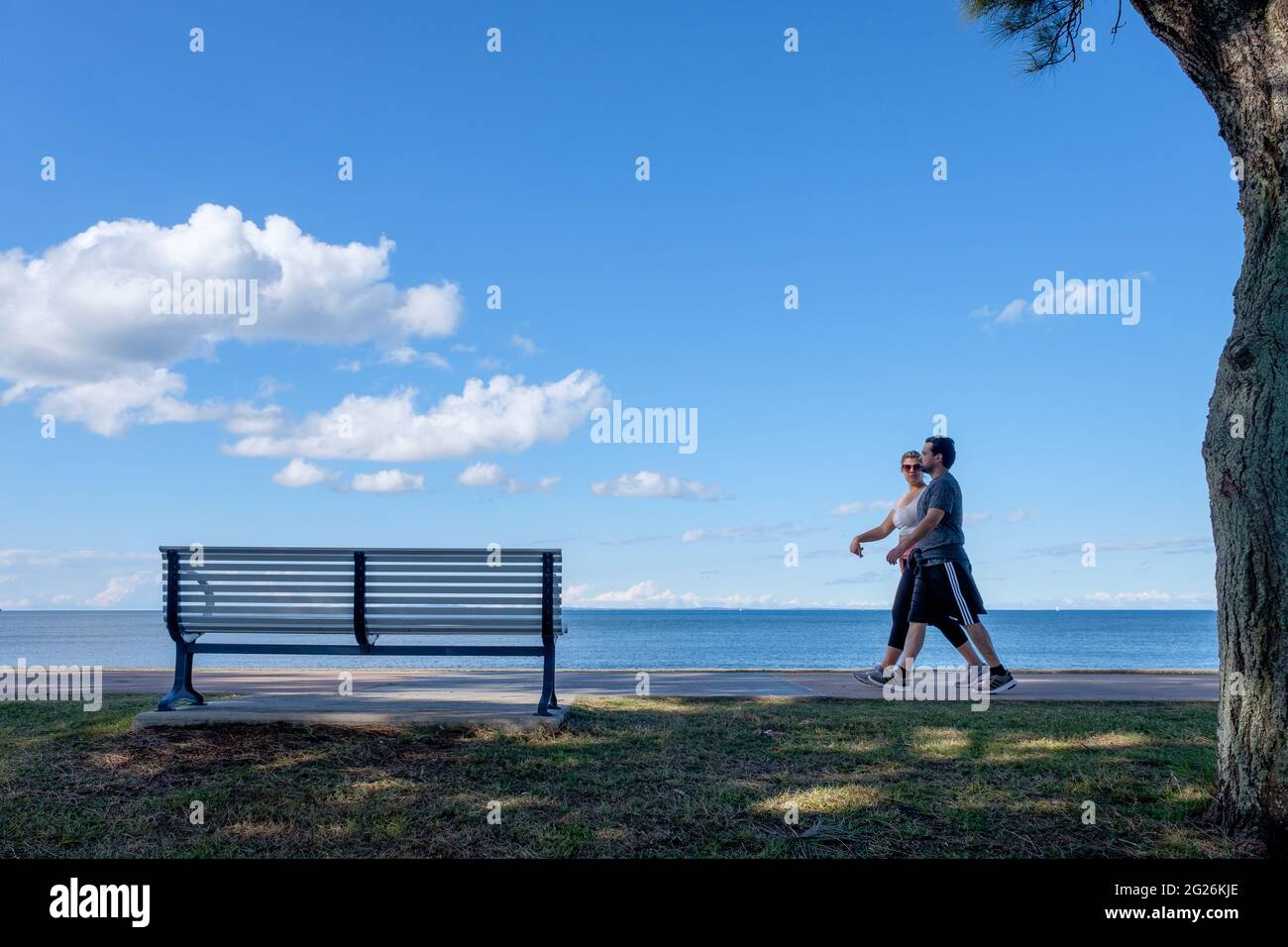 Ein Paar, das am Ufer bei Sandgate entlang läuft Stockfoto