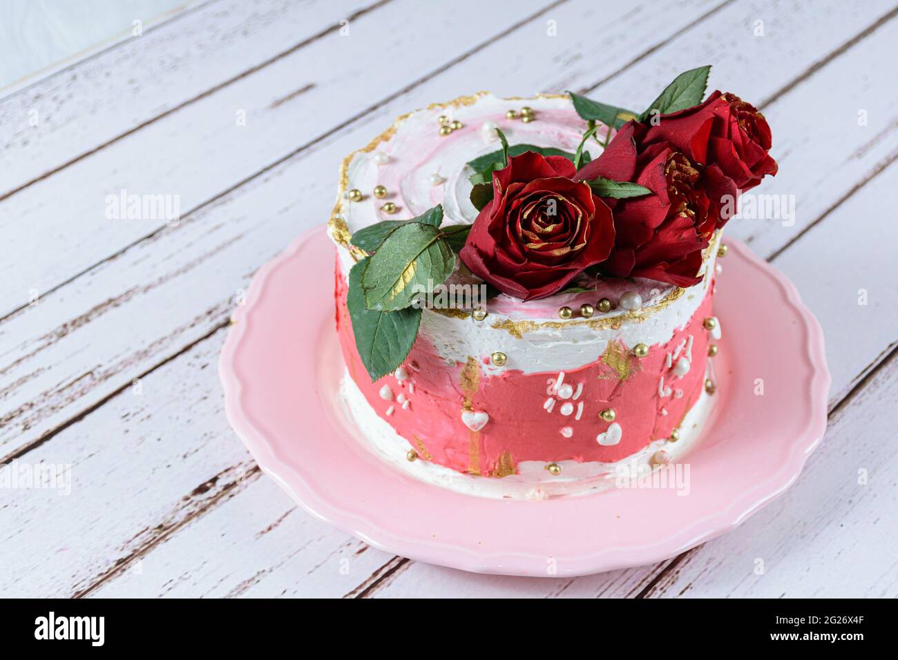 Schokoladenkuchen mit Schweizer Baiser Buttercreme, mit roten Blumen zum Verzieren. Stockfoto