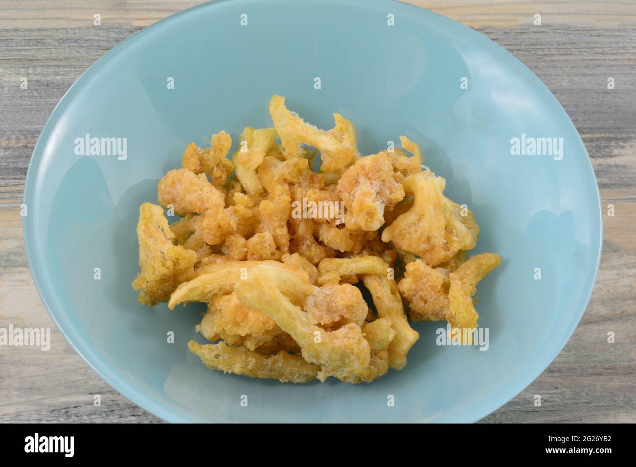 Weißer Cheddar-Blumenkohlbärsnack in blauer Schleife auf dem Tisch Stockfoto