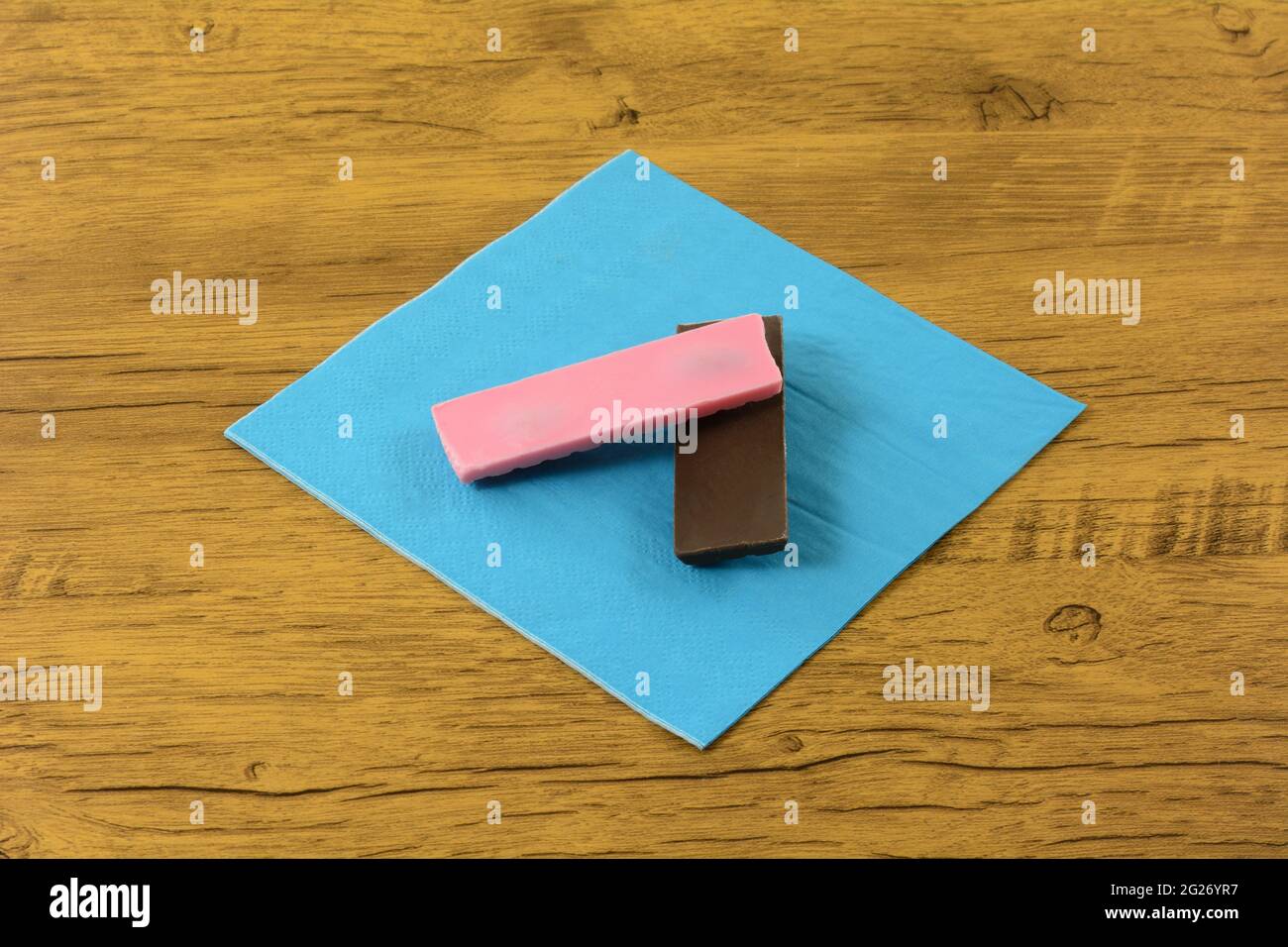 Milchschokolade und Erdbeer-Süßigkeitenbar auf blauer Snack-Serviette Stockfoto