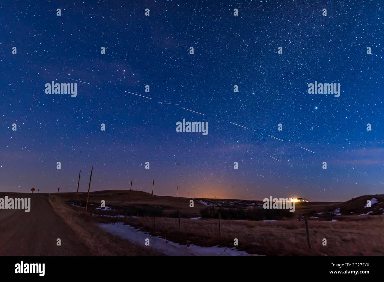 Ein Pass des Satellitenzuges Starlink 4 in der Dämmerung über dem Land in Kanada. Stockfoto