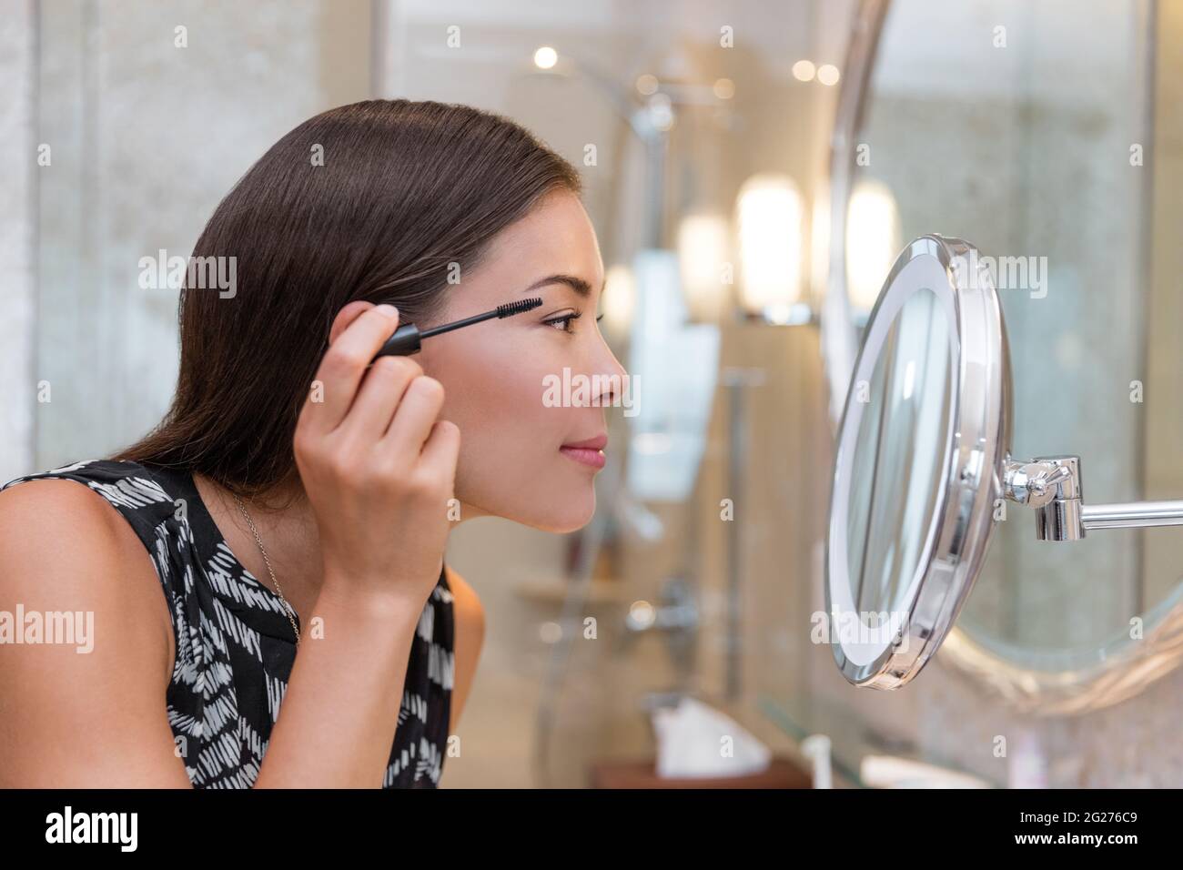 Frau immer bereit für die Arbeit tun Morgen Make-up Routine Putting Mascara in Badezimmerspiegel zu Hause. Schöne asiatische Geschäftsfrau Anwendung Auge machen Stockfoto