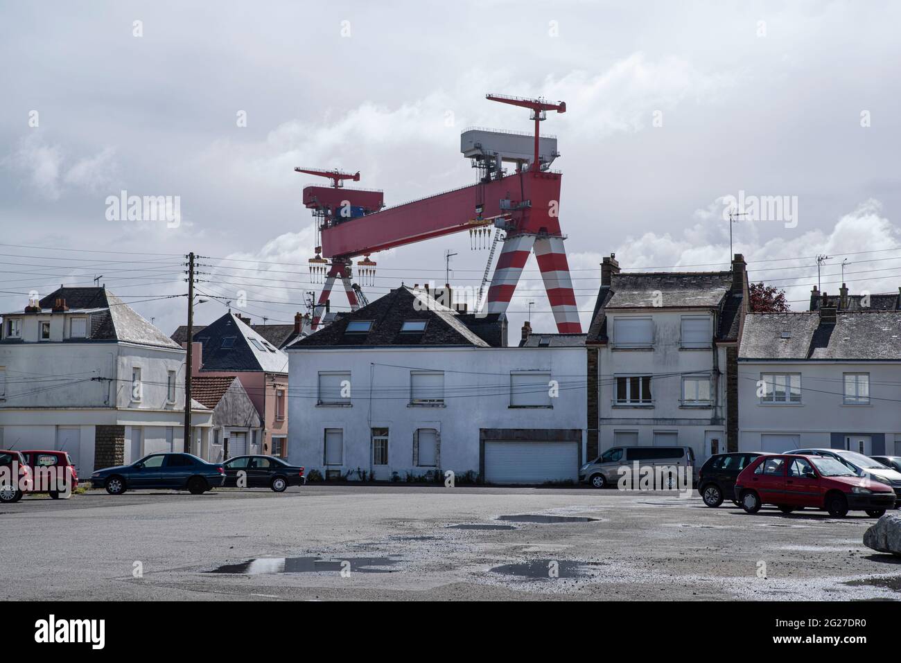 Kran im Hafen von Saint Nazaire in Frankreich hinter Wohnhäusern Stockfoto