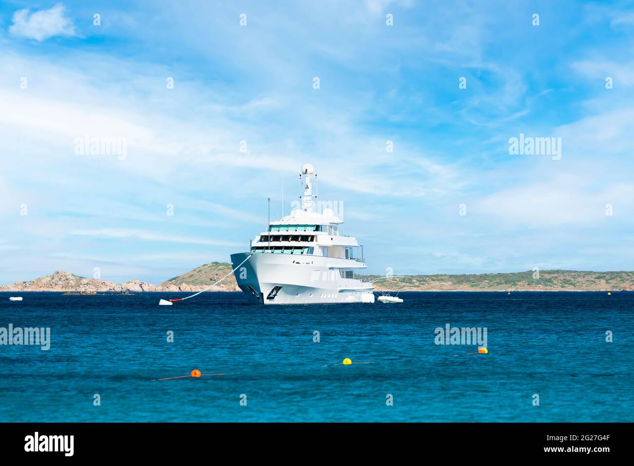 Atemberaubender Blick auf ein weißes Luxusboot, das an einem sonnigen Tag auf einem ruhigen, türkisfarbenen Meer schwimmt. Porto Cervo, Sardinien, Italien. Stockfoto