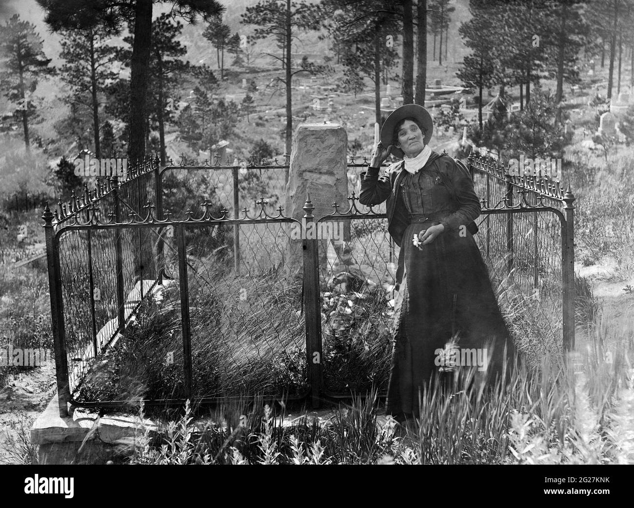Unheil Jane steht neben dem Grab von Wild Bill Hickok in Deadwood, South Dakota. Stockfoto