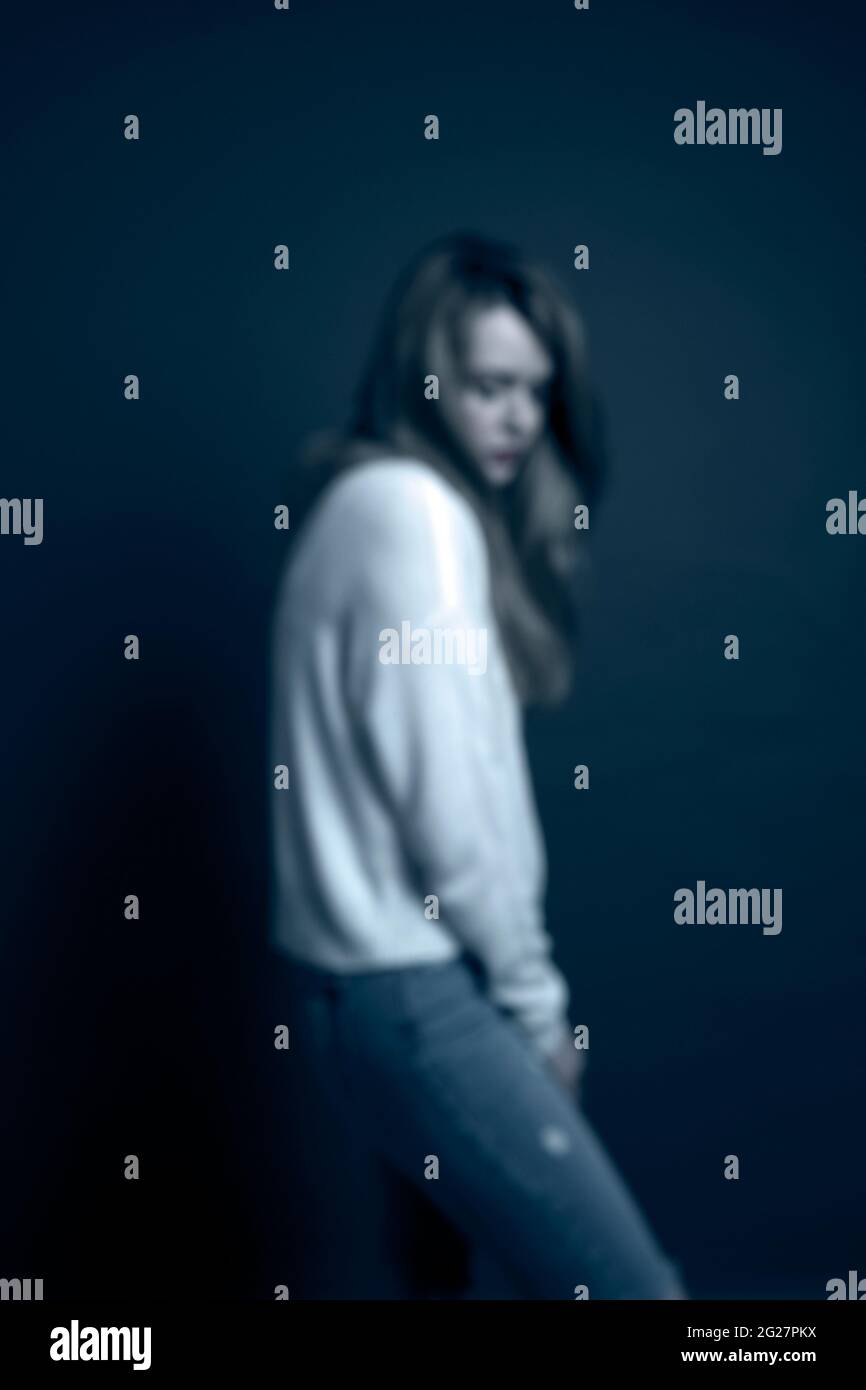 Traurige, verschwommene Frau mit weißem Polokragen Stockfoto