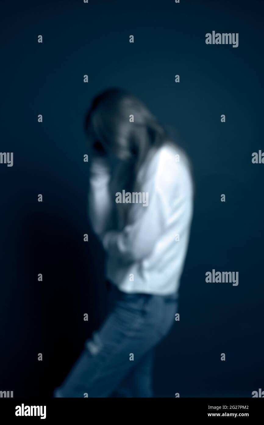 Traurige, verschwommene Frau mit weißem Polokragen Stockfoto