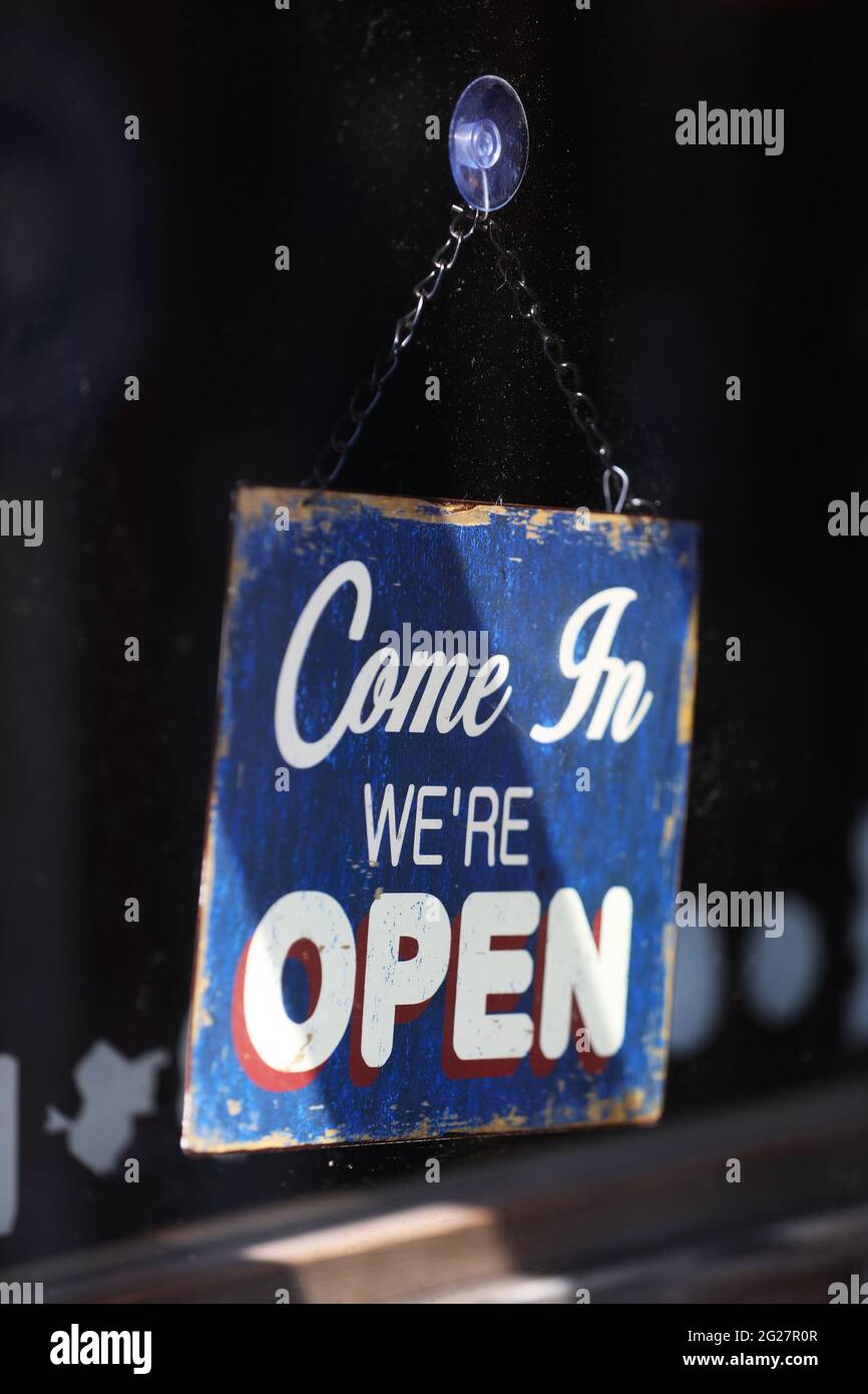 "Wir sind offen" -Schild an einer Tür in Chichester, West Sussex, Großbritannien. Stockfoto