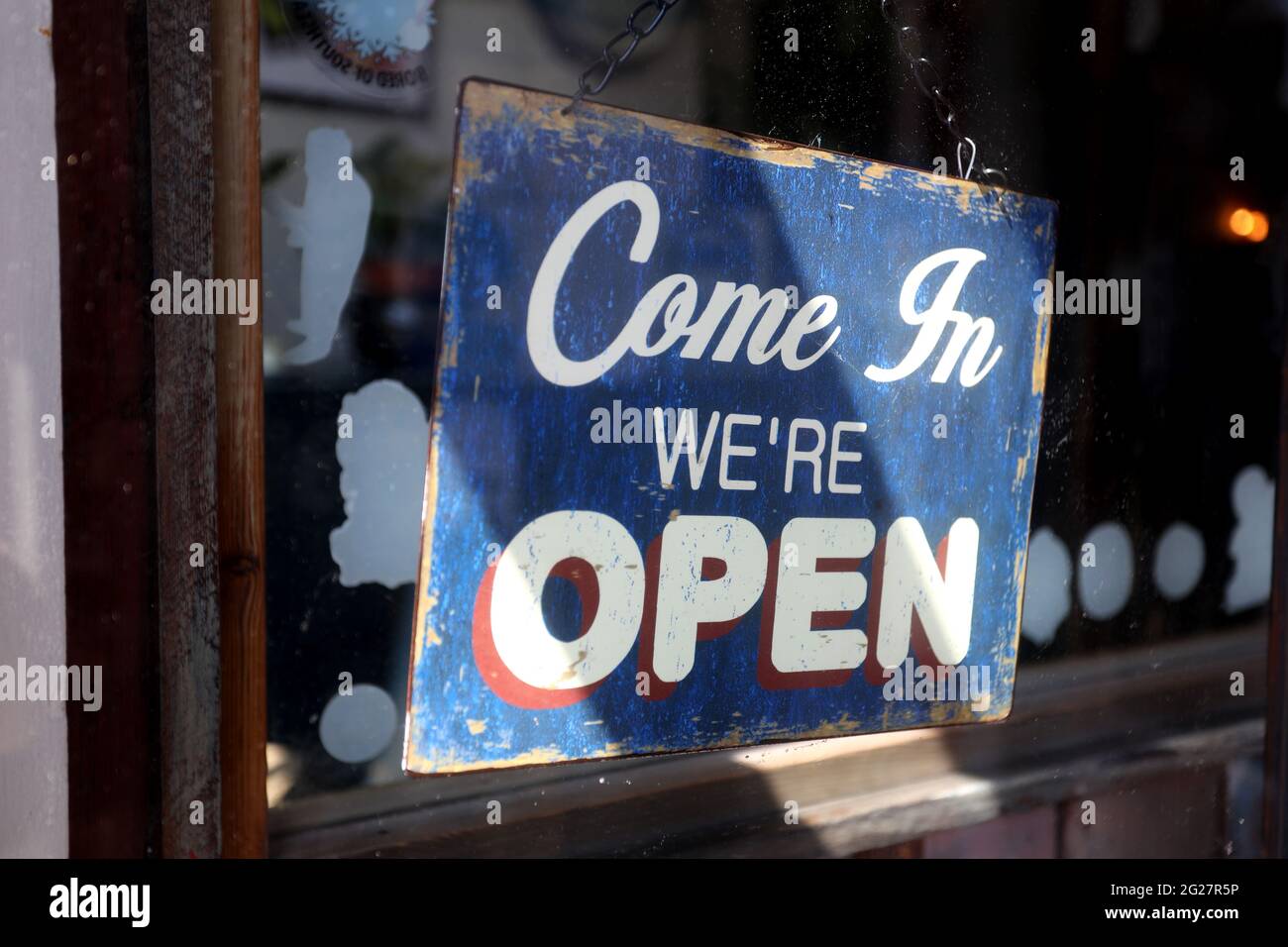 "Wir sind offen" -Schild an einer Tür in Chichester, West Sussex, Großbritannien. Stockfoto