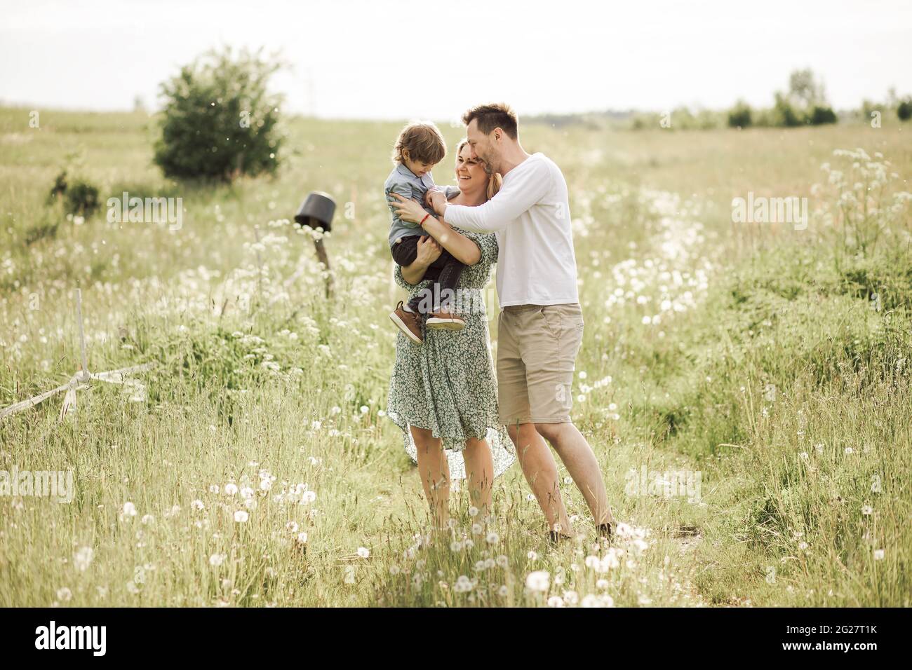 An einem sonnigen Sommertag macht die junge Familie einen Spaziergang mit ihrem Sohn. Adoptionskonzept Stockfoto