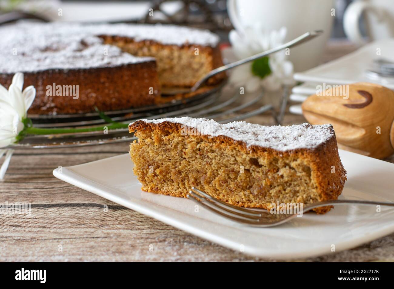 Ein Stück Kuchen. Traditionelle spanische Mandelkuchen auf einem weißen Teller mit Gabel auf rustikalem Tisch backgroiund serviert. Stockfoto