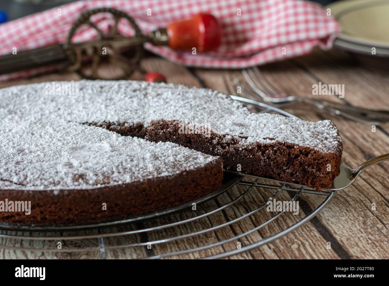 Köstliche schwedische Schokoladenkuchen kladdkaka ohne Backpulver gebacken und serviert auf einem Kühlregal auf rustikalen und hölzernen Tisch Hintergrund Stockfoto
