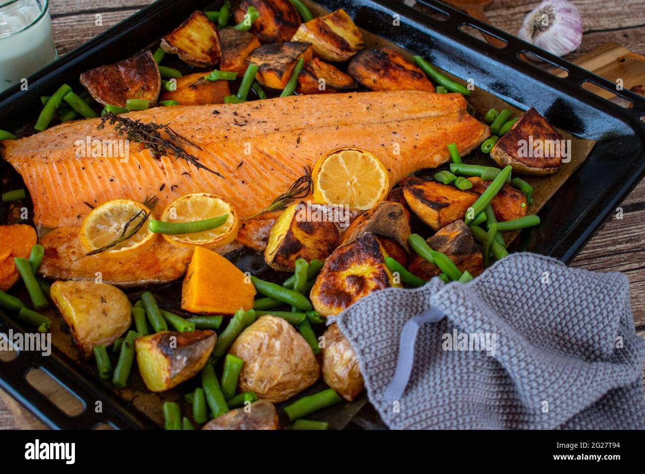 Mediterranes Fischgericht mit Gemüse und Süßkartoffeln auf einem Backblech von oben serviert. Nahaufnahme und abgelegene Sicht. Stockfoto