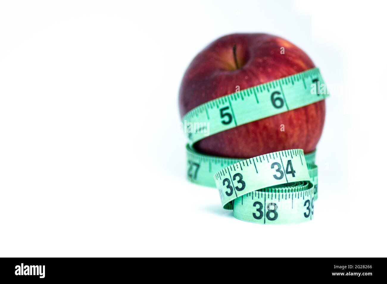 Verschwommener roter Apfel mit Messband isoliert auf weiß - Diät-Konzept Stockfoto