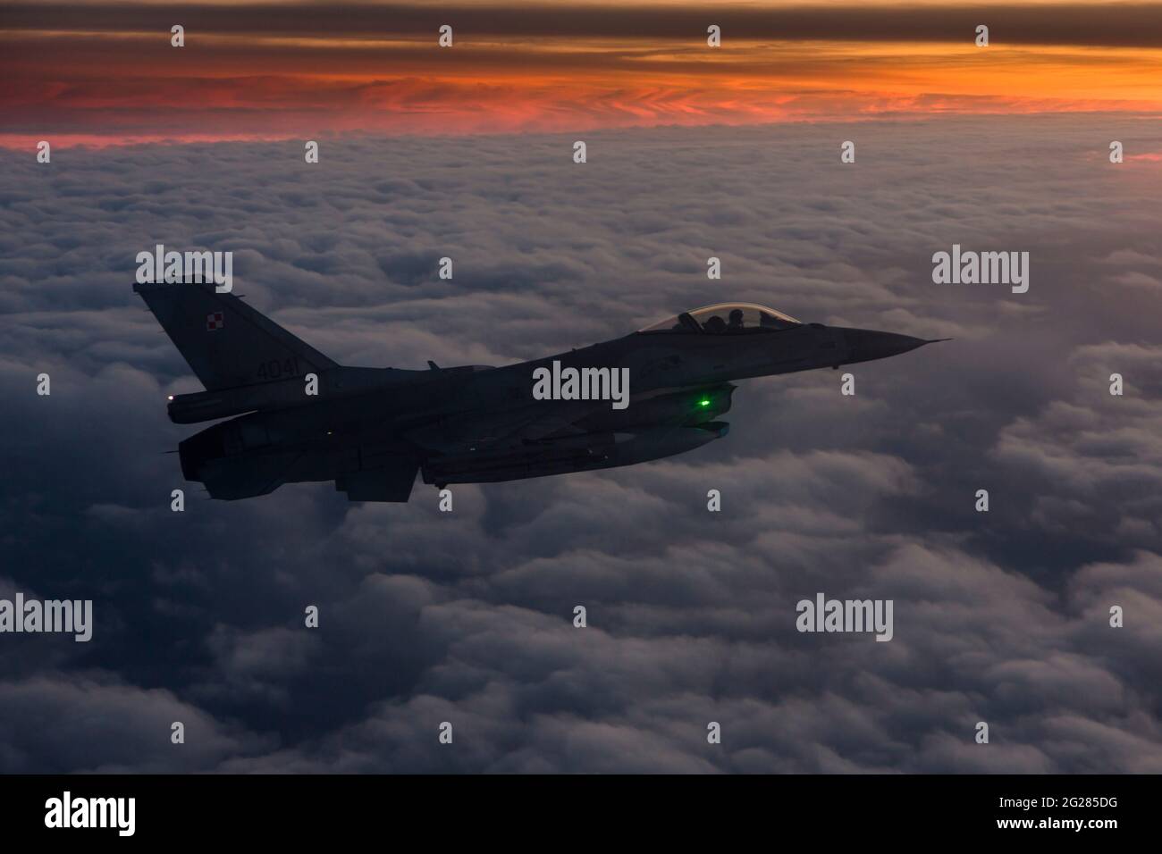 Der F-16C-Jet der Polnischen Luftwaffe fliegt über den Wolken über Polen. Stockfoto