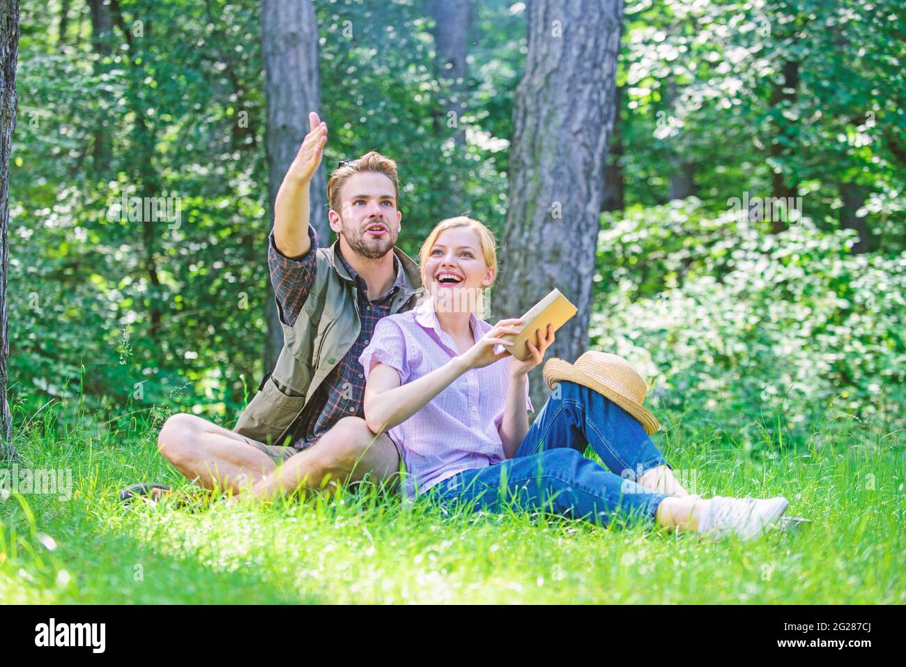 Romantische Paar Studenten genießen Freizeit Blick nach oben beobachten Natur Hintergrund. Verliebte Paare verbringen ihre Freizeit im Park oder im Wald. Romantisches Date in Stockfoto