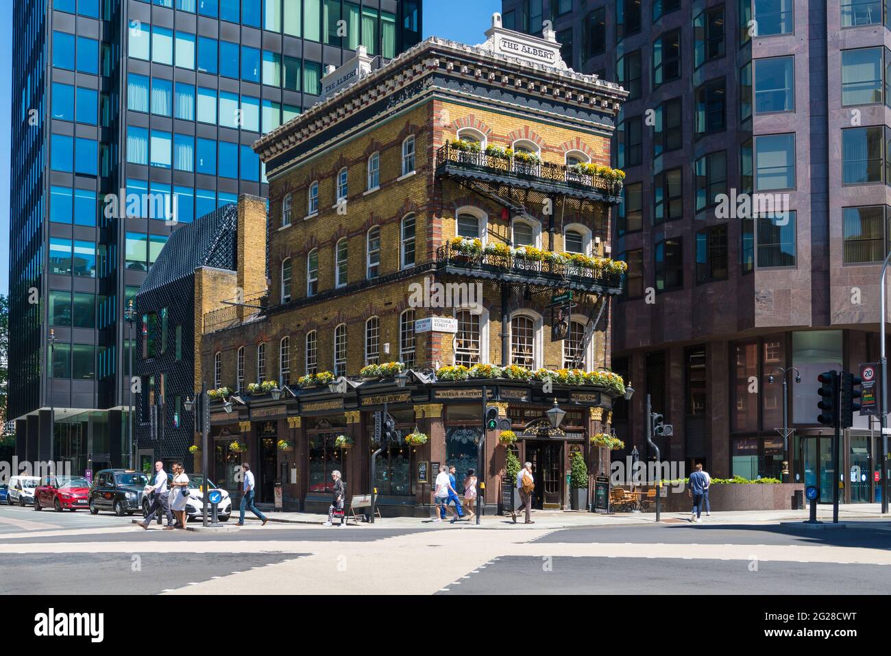 An einem sonnigen Tag kommen die Menschen am Albert Pub vorbei, das sich an der Ecke Victoria Street und Buckingham Gate befindet. London, England, Großbritannien Stockfoto