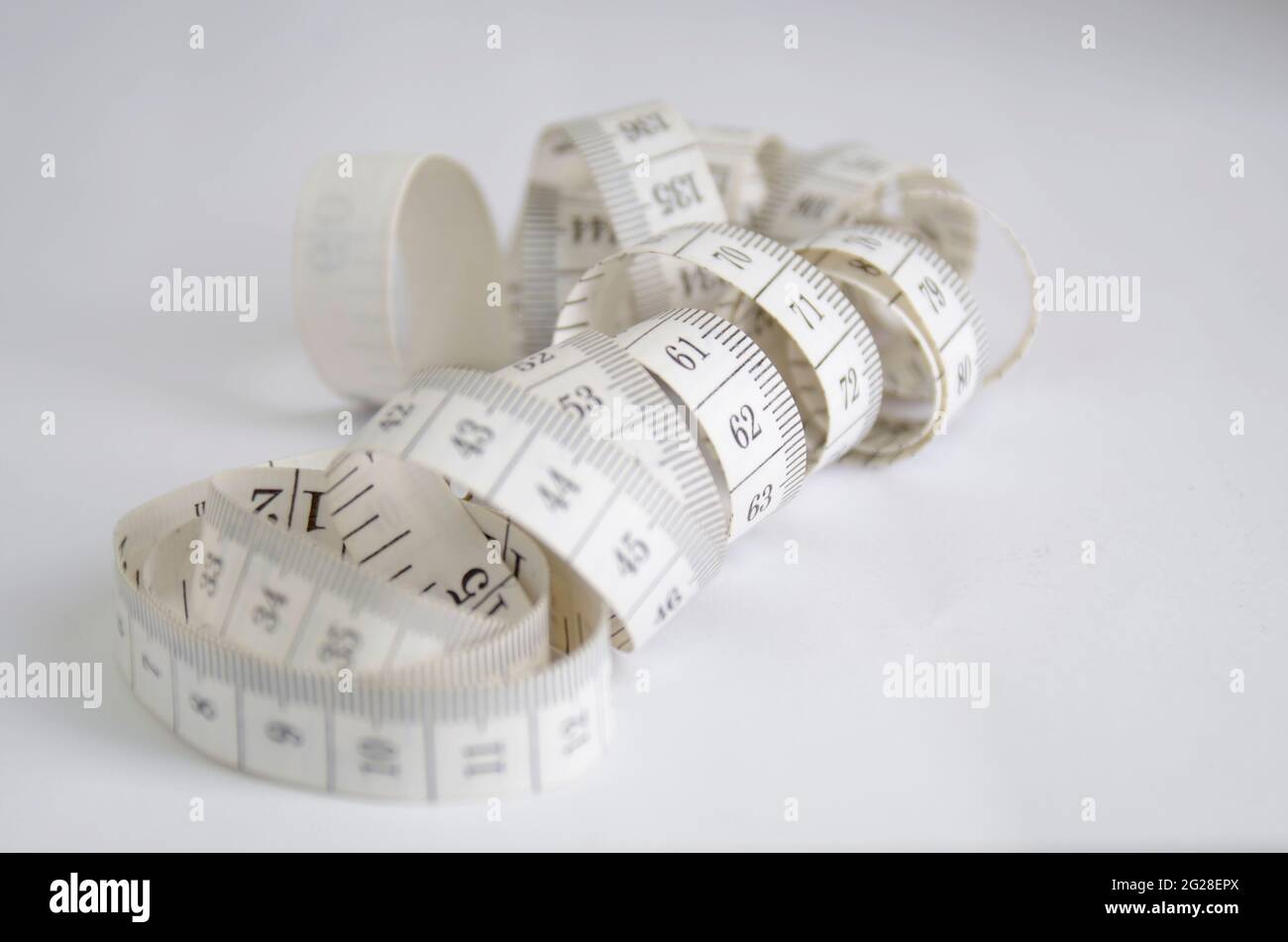 Maßband, zur Messung des Körpers.konzeptionelle Bilder zur Messung von Produktivität, Wachstum, Gewichtszunahme, Ernährung, gesundes Leben und andere Stockfoto